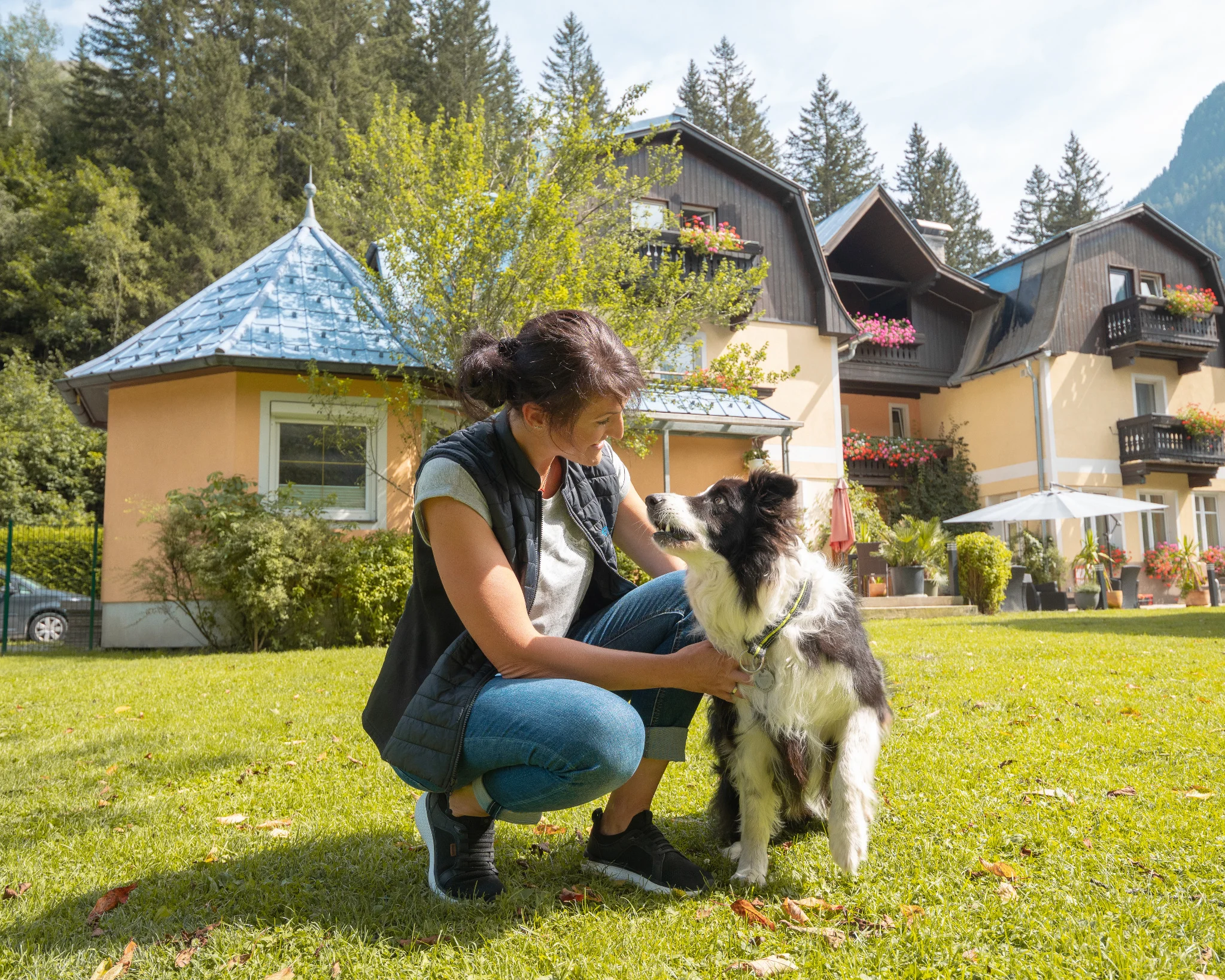 Hundetrainerin Conny Pfund beim Training mit Border Collie im Garten des GRUBERS Hotel-Apartments Gastein