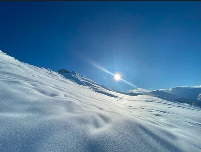 Winterlandschaft in Gastein mit Sonne über verschneiten Bergen – ideal für Winterwanderungen mit Hund
